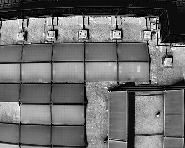 White Hot thermal image of a rooftop solar panel array showing some cell defects